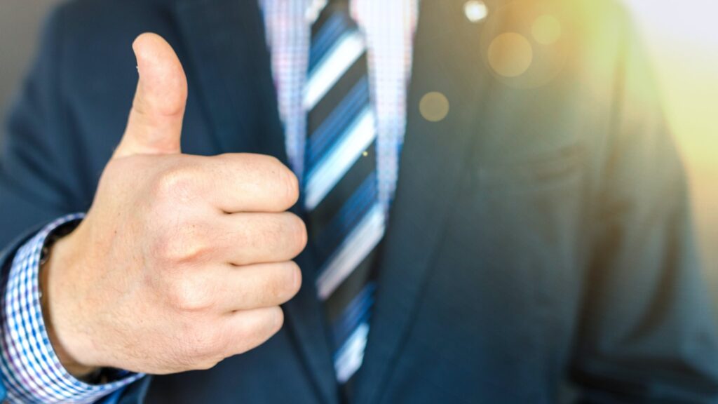 man in suit holding thumbs up